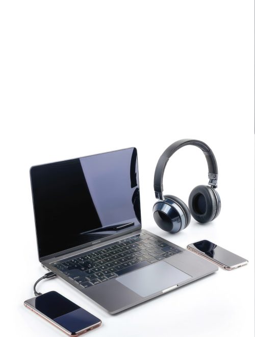 A laptop, two cell phones and headphones are on a white background A laptop, two cell phones and headphones are on a white background. Concept of productivity and technology use